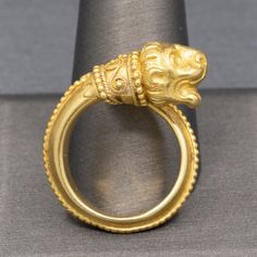 Ilias Lalaounis Greek Chimera Lion Wrap Bypass Ring in 18k Yellow Gold This eternal creature rests with his mouth open as if waiting for the next bite!  This ring by Ilias Lalaounis features one of the maker's most famous motifs.  The tail of the creature wraps around the finger and features granulated baed work on the ridge line of the band.  The 750 mark and the Greece marks are seen under the collar.  The ring is a size 7.5 with a little flex- it would fit a size 7.5-8.  The ring is crafted i Ilias Lalaounis Jewelry, Bypass Ring, Ancient Jewelry, Gems And Minerals, Rings Statement, Statement Rings, The Ring, Solid Gold, Jewelry Rings