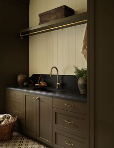 a kitchen with black counter tops and gold faucets on the sink, along with brown cabinets