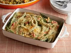 a casserole dish filled with green beans and other food items on a table