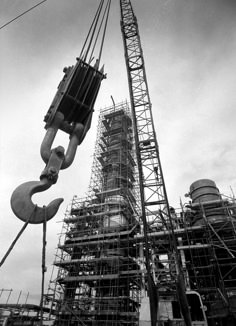 an old photo of a large crane in front of a building with scaffolding on it