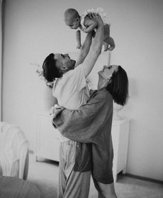 a man holding a baby up in the air