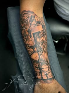 a man with a cross and lion tattoo on his arm