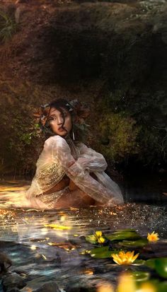 a woman is sitting in the water surrounded by lily pads and leaves, with her hands on her knees