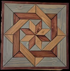 a wooden wall hanging with an abstract design on it