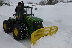 a tractor that is sitting in the snow with its front end shoveled up to it