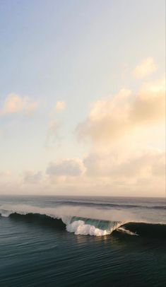 two surfers are riding the waves on their surfboards in the ocean at sunset