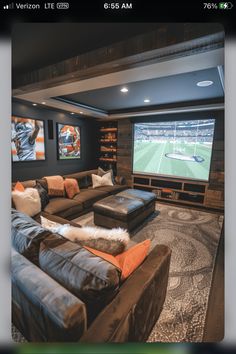 a living room with couches and a large screen tv in it's center