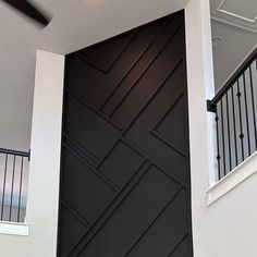 a black and white door in a room with some stairs leading up to the second floor