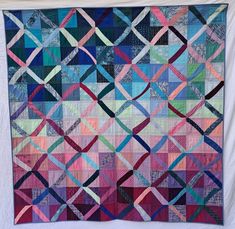 a colorful quilt is hanging on the wall