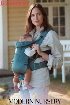 a woman carrying a baby in a green sling on the cover of a magazine called modern nursery