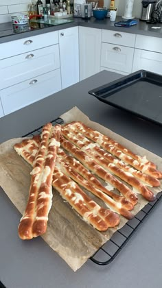 some bread sticks are sitting on a baking sheet in the kitchen, ready to be baked