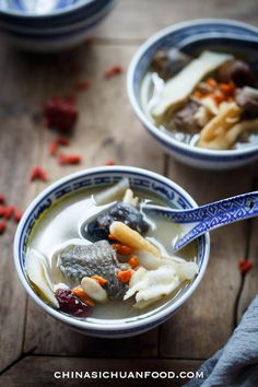 two bowls filled with soup on top of a wooden table