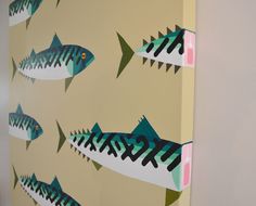 a wall with fish painted on it in the shape of an arrow and letters that spell out