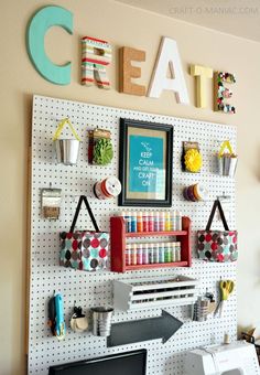 a craft room with pegboard, computer and sewing supplies on the wall next to it