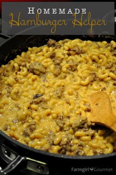 macaroni and cheese is being cooked in the crock pot with a wooden spoon