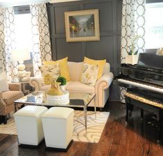 a living room filled with furniture and a piano in front of a large painting on the wall