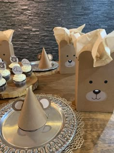 some cupcakes are sitting in paper bags on a table with other items around them