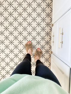 a person standing in front of a patterned wall