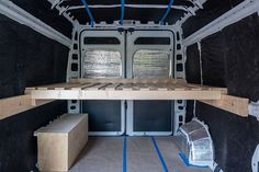 the inside of an empty van with blue piping on the floor and black walls