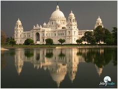 a large white building sitting next to a body of water