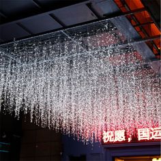 a large chandelier hanging from the ceiling in front of a building with chinese characters on it