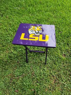 a purple and yellow table sitting on top of a lush green field