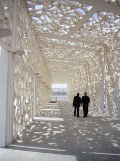 two people are walking down the walkway in an art installation that looks like it is made out of paper