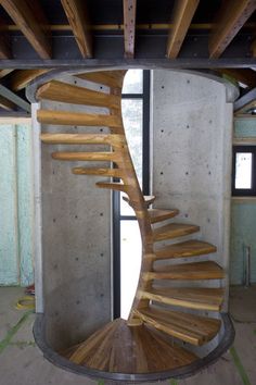 a wooden spiral staircase in an unfinished room