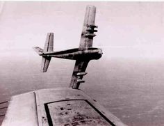 an old airplane flying over the ocean on a foggy day in black and white