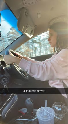 a woman driving a car with the sun shining on her