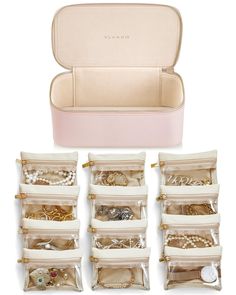 the inside of a pink case filled with jewelry