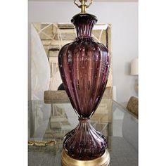 a purple vase sitting on top of a glass table