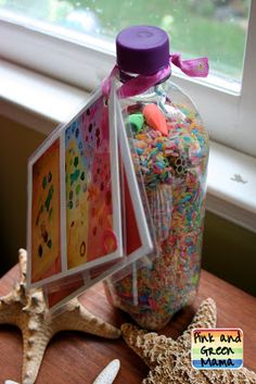 a plastic bottle filled with confetti on top of a table next to starfish