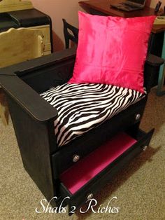 a zebra print chair with pink and black pillows on it in front of a desk