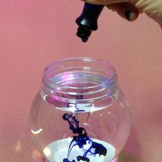 a person is pouring something into a glass jar