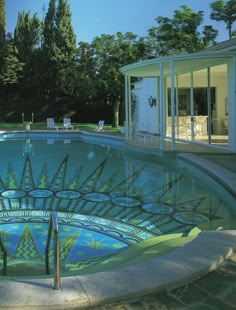 an outdoor swimming pool surrounded by trees and lawn chairs in the background, with sun shining through glass windows