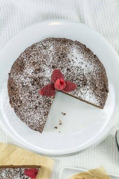 a chocolate cake with raspberries on top and powdered sugar on the bottom