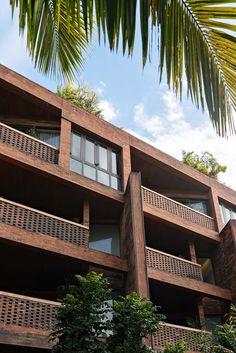 an apartment building with balconies and trees in the foreground