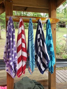 several colorful towels hanging from a wooden rack