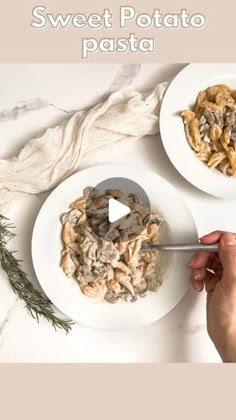 two white plates with pasta and mushrooms on them, one being spooned into the bowl