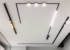 an empty room with white walls and black trimmings is lit by recessed lights