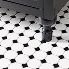 a black and white checkered tile floor with a sink in the middle on top of it