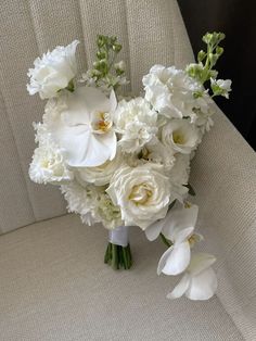 a bouquet of white flowers sitting on top of a couch