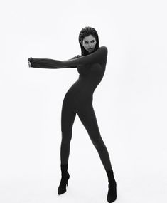 a woman in black bodysuit posing with her arms out and hands behind her back