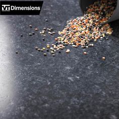 a bucket filled with lots of food on top of a black counter next to a cup