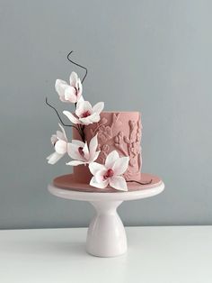 a pink cake with white flowers on top