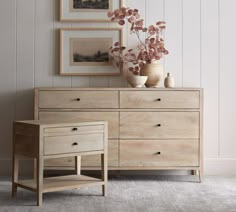 a wooden dresser with two vases on top of it