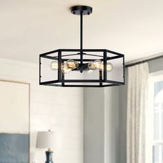 a black chandelier hanging from the ceiling in a living room with white walls