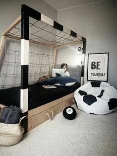 a bedroom with a bed made to look like a soccer goal and a person sitting on the bed