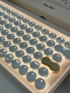 a close up of a computer keyboard with buttons on the back side and an illuminated key board behind it